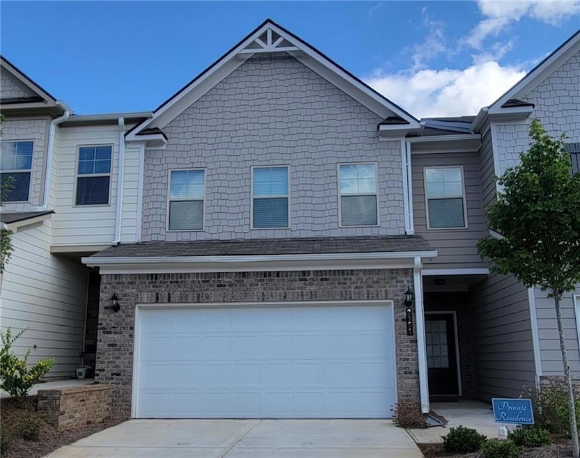 View of property featuring concrete driveway and a