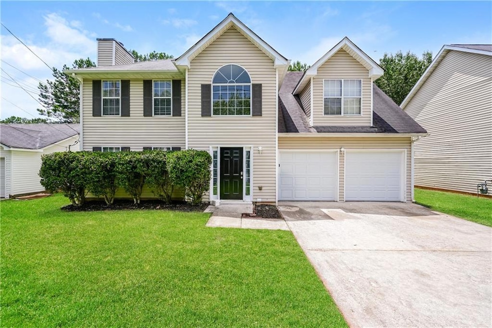 Traditional home with concrete driveway, a front yard, a chimney, and a shingled roof