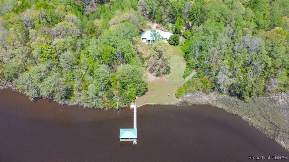 Drone view of homesite, pier and covered dock