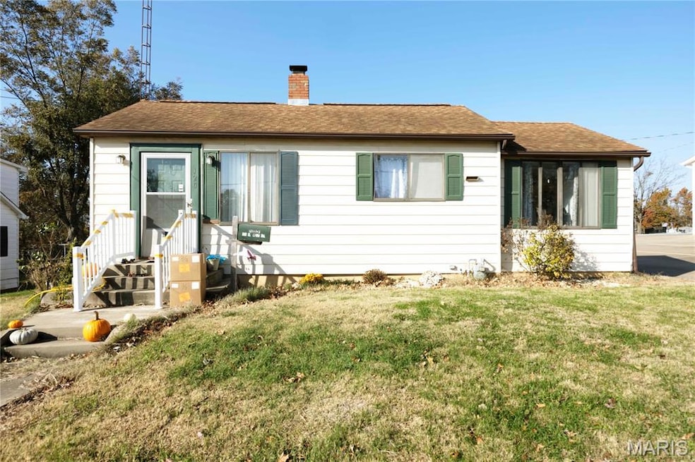 Ranch-style house featuring a chimney, a shingled roof, and a front lawn