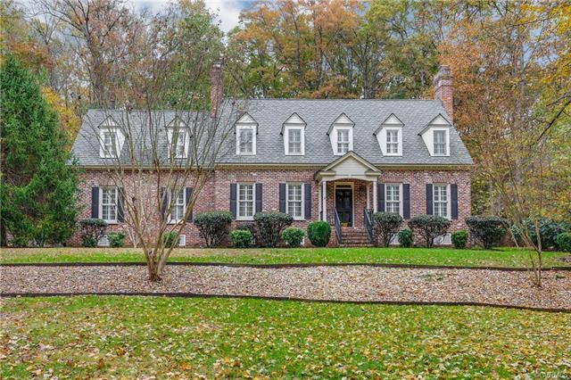 Mostly brick Cape with newer Grand Manor roof sits