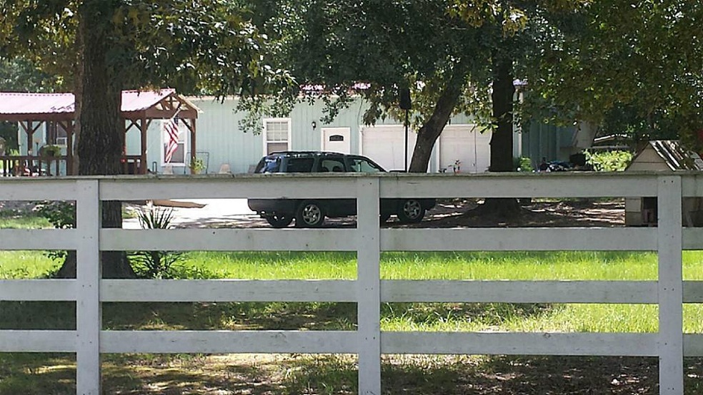 Blue addition with mobile home behind addition