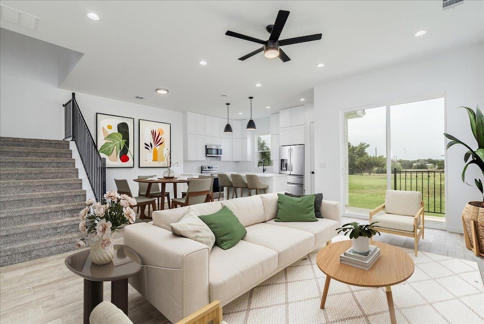 Open living area with kitchen, dining, and access to outdoor patio.