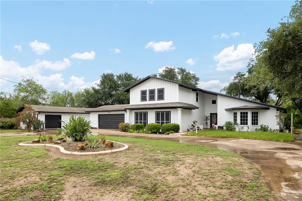 View of front of house featuring a garage, driveway, and a front lawn
