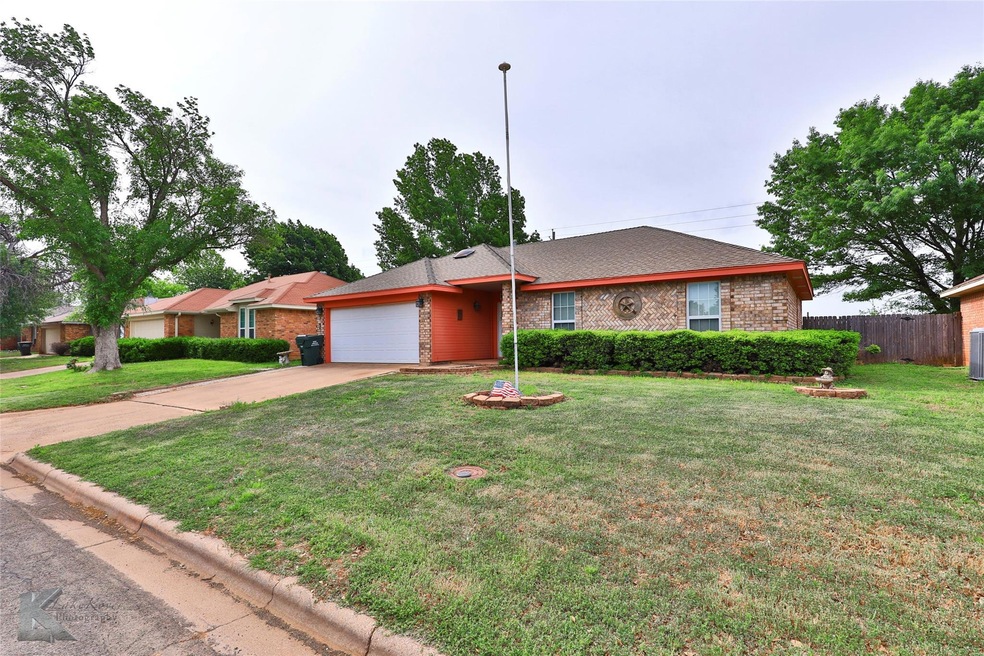 Ranch-style house featuring a garage and a front y