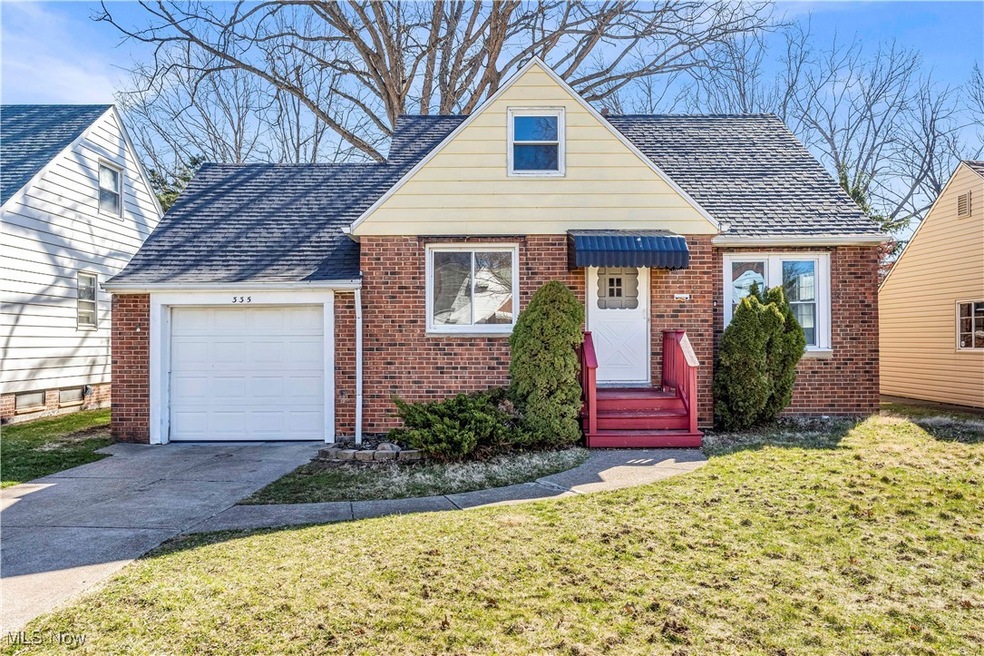 View of front of property featuring brick siding, an attached garage, driveway, and roof with shingles