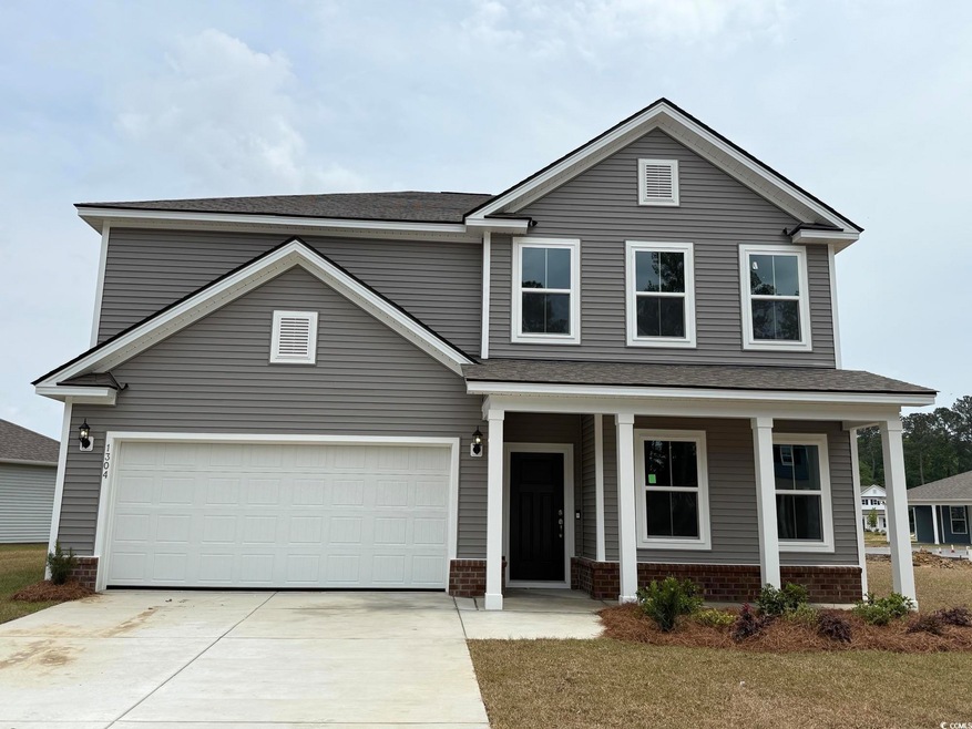 Traditional home featuring brick siding, a garage,