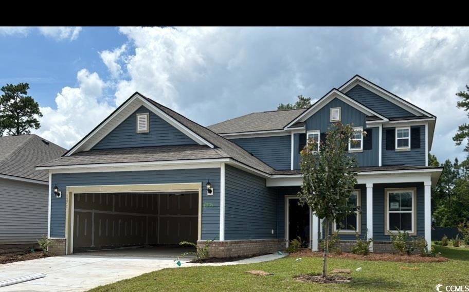 Craftsman-style home with a front lawn and a garag