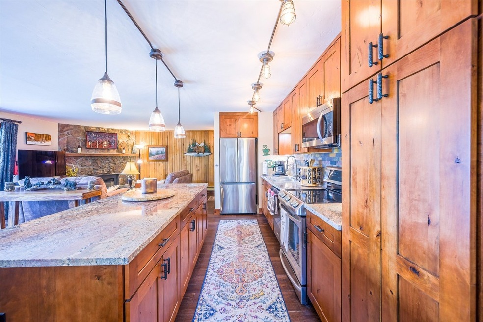 Kitchen with dark hardwood / wood-style floors, li