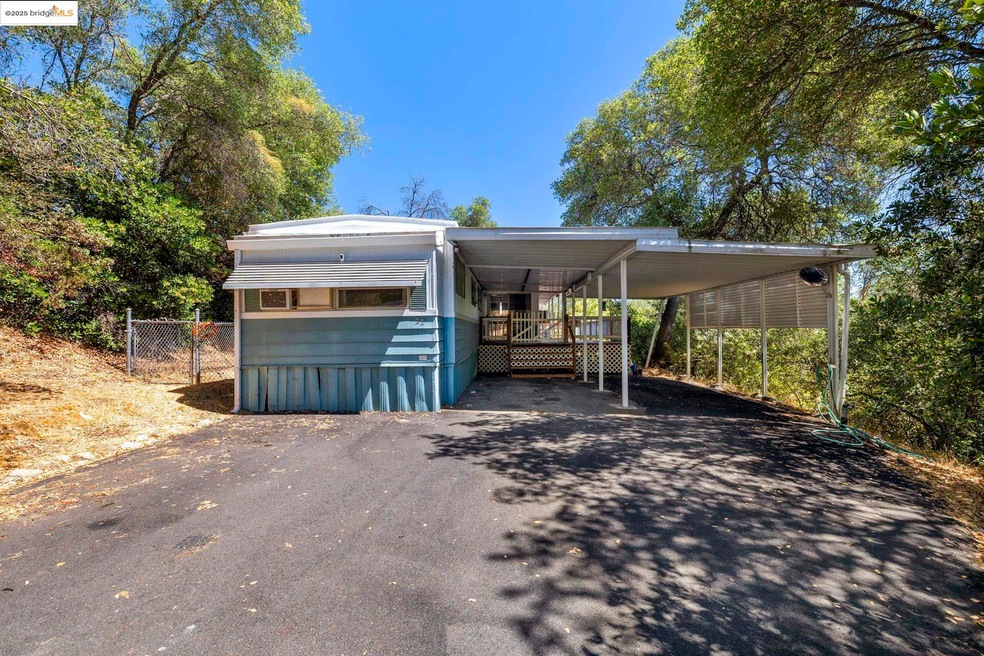 View of front facade featuring a carport and driveway