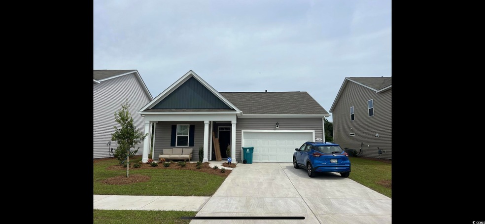View of front of home featuring a front lawn, a ga