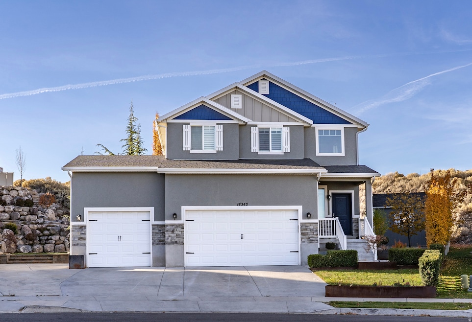 Craftsman-style home with stone siding, concrete driveway, and stucco siding