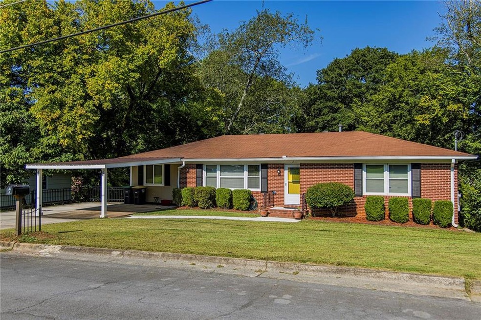 Ranch-style home with a carport and a front lawn