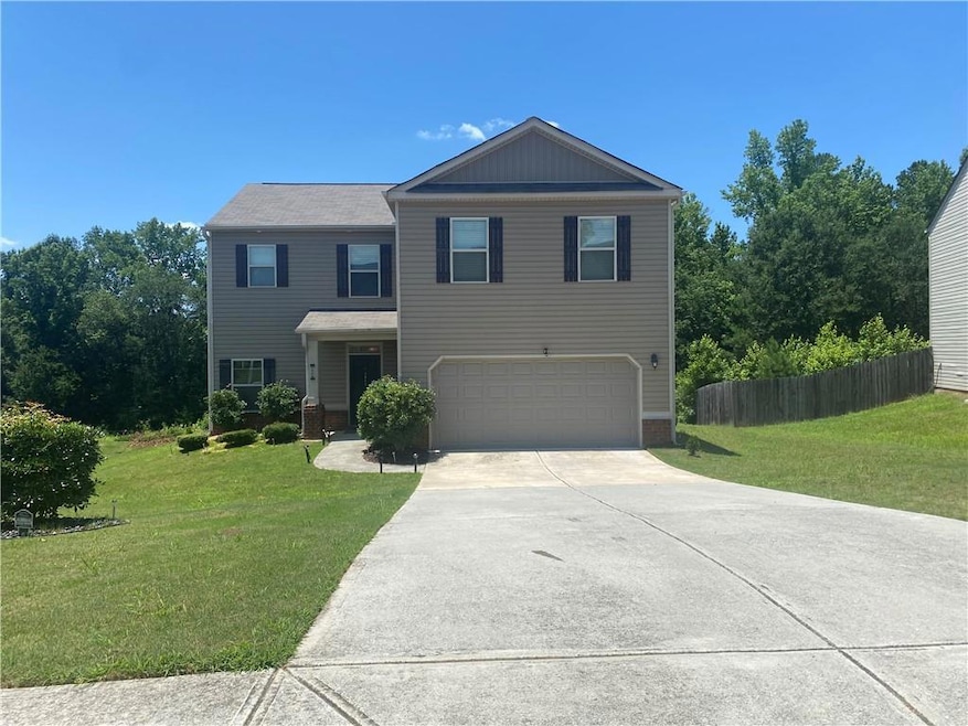 View of front of home with a garage and concrete driveway
