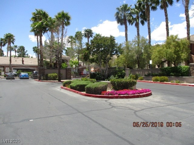 View of asphalt road with curbs and a gated entry
