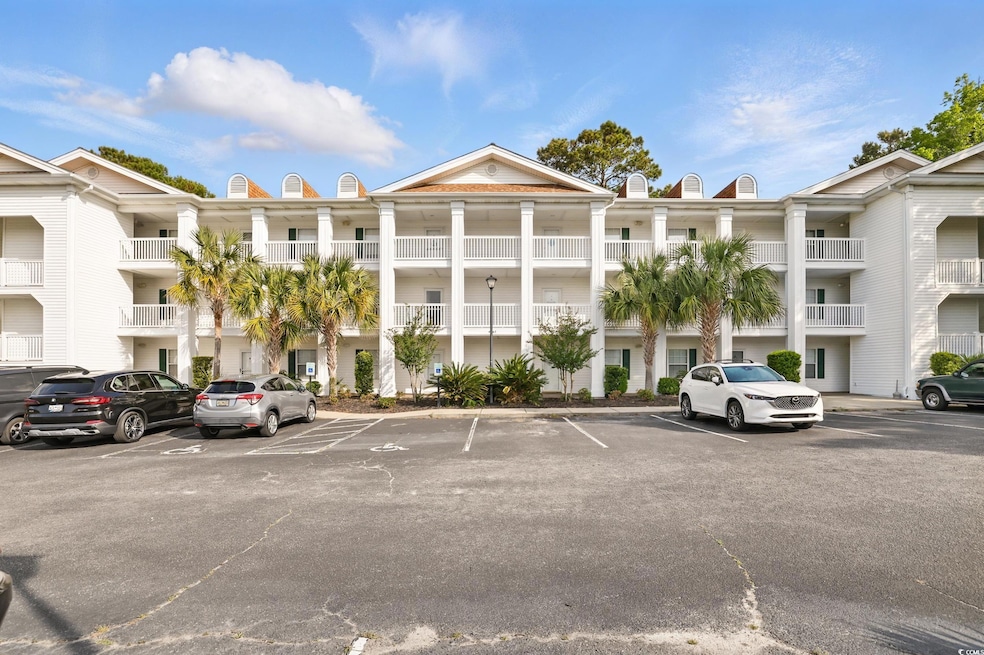 View of building exterior with uncovered parking