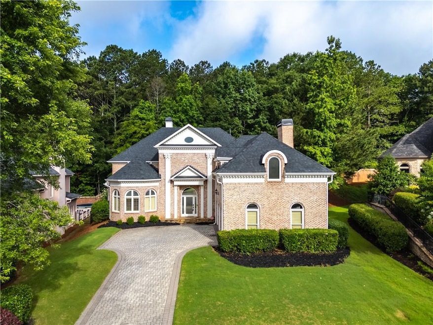 Greek revival house with a chimney, brick siding, and a front yard