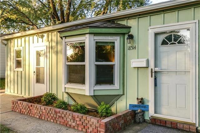 Front of home showing bay window and metal siding.