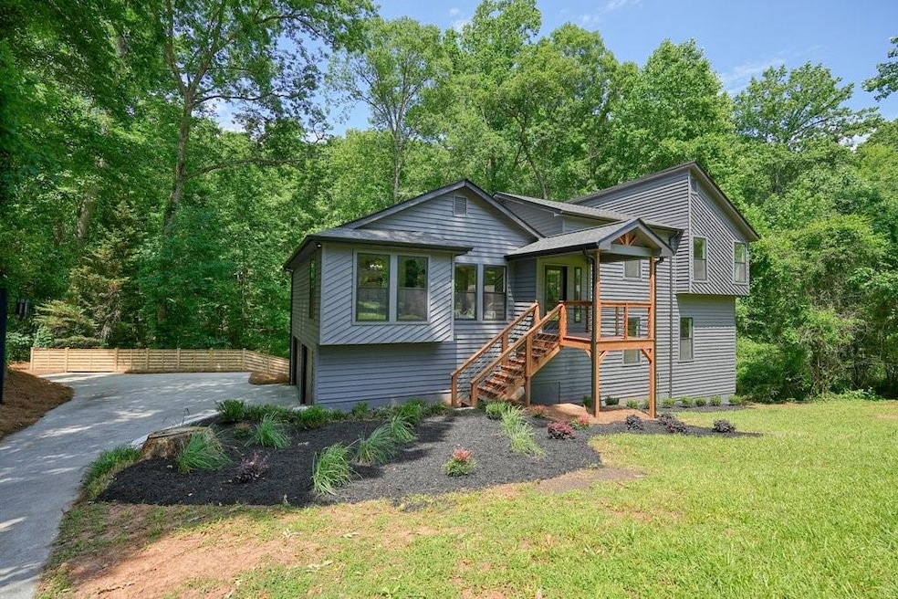 Front of home with stairway, driveway, and a front yard