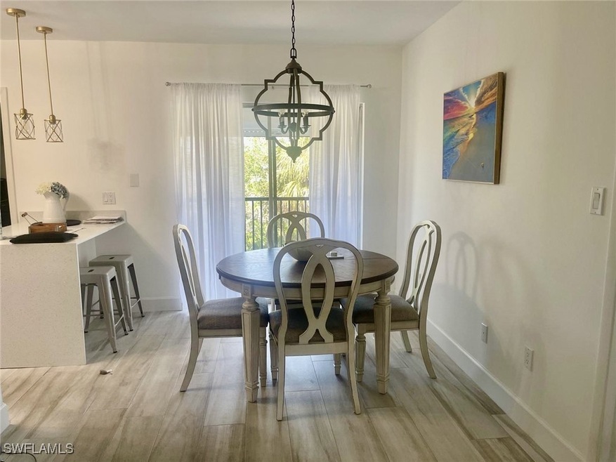 Dining area featuring baseboards, an inviting chandelier, and light wood-style floors