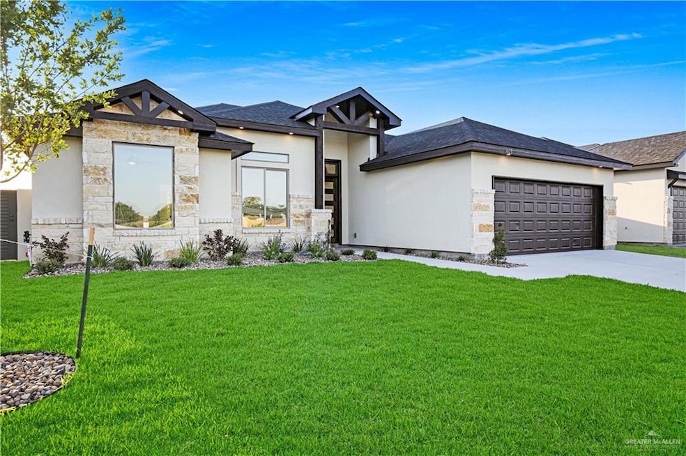 Prairie-style house featuring an attached garage, stone siding, a front yard, and concrete driveway