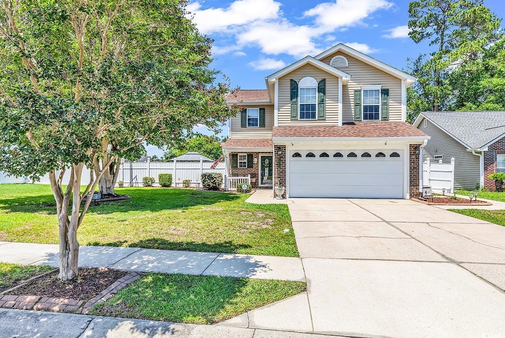 View of front of home with an attached garage, dri