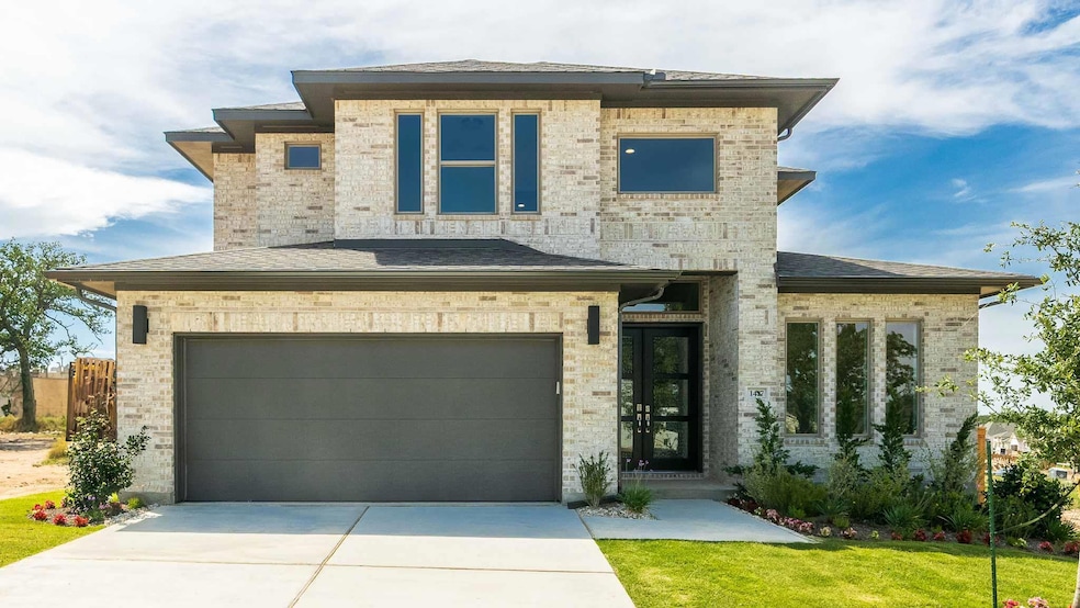 View of front of home with driveway, an attached 