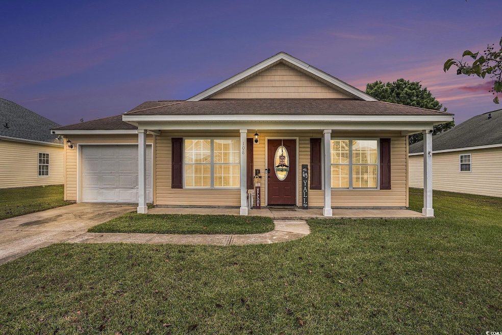 View of front of property with a shingled roof, a porch, a yard, and driveway