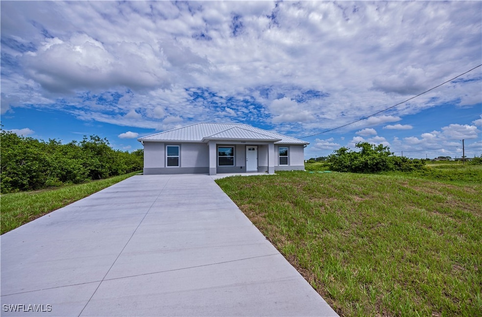 View of front of house with stucco siding and driv
