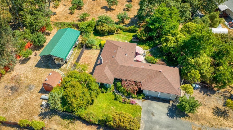 RV enclosure on left hand side  and house on the right with lots of trees for privacy