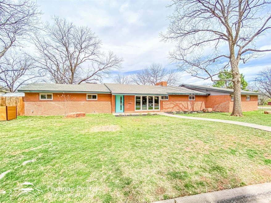 Ranch-style house featuring brick siding, a chimne