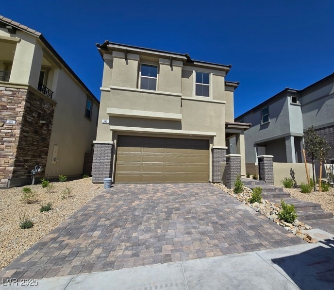 View of front facade with a garage, stucco siding,