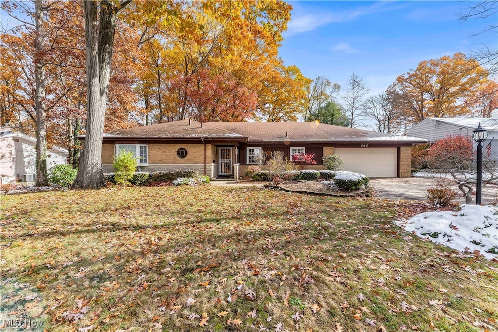 Ranch-style house with a front yard, a garage, driveway, and brick siding