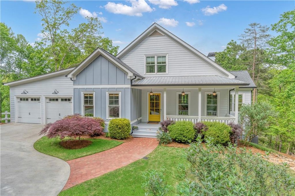 View of front of home with a porch, a garage, driv