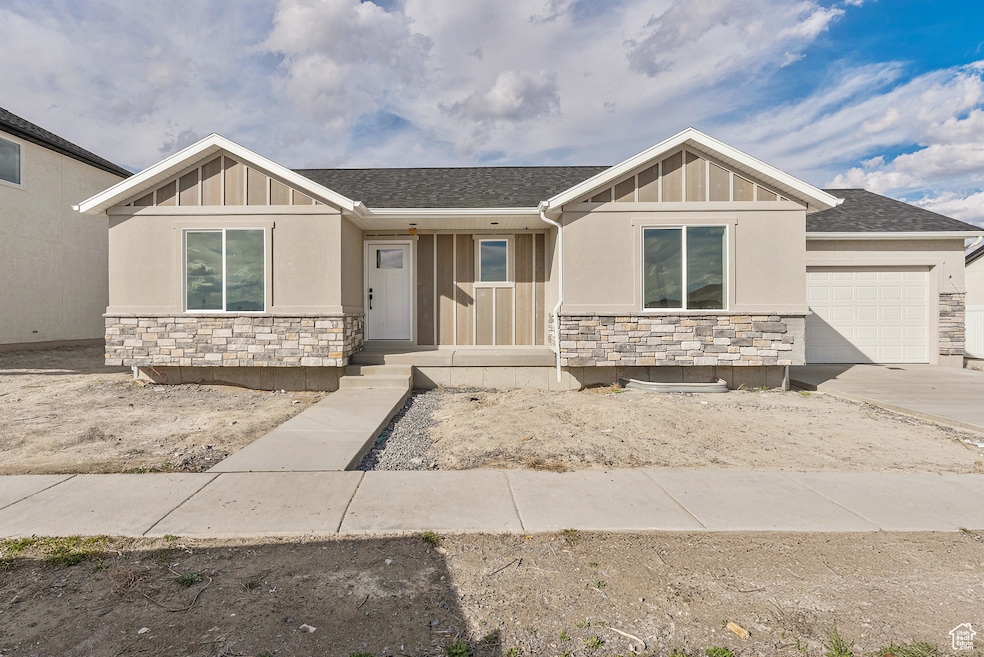 Craftsman-style home featuring stone siding, board and batten siding, roof with shingles, and an attached garage