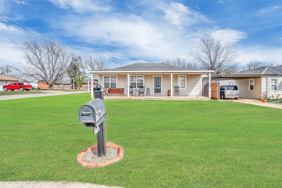 Single story home featuring a front lawn, a carpor