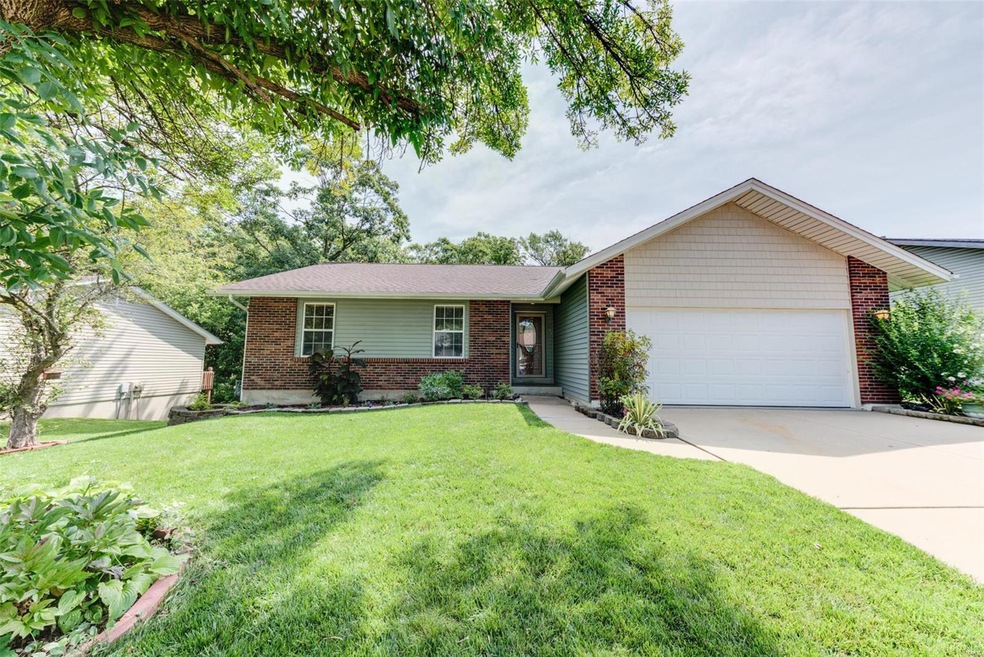 Beautifully landscaped yard leads to covered porch