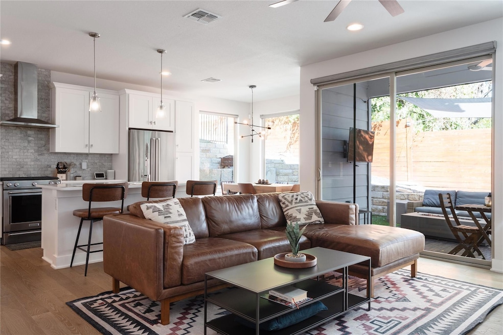 Living area with a ceiling fan, wood finished flo
