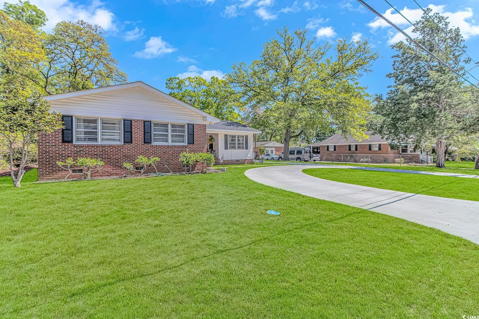 Single story home featuring curved driveway, brick
