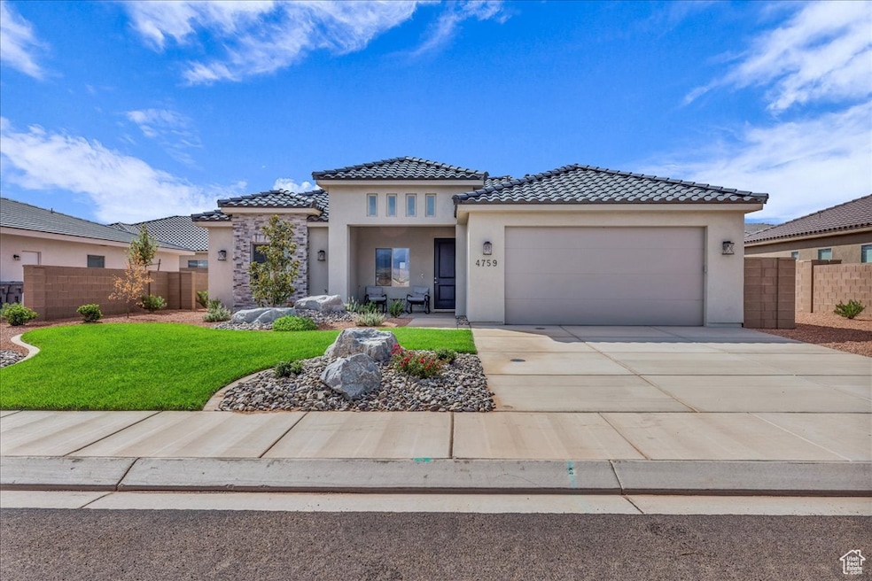 View of front of house featuring stucco siding, driveway, a garage, and a tiled roof