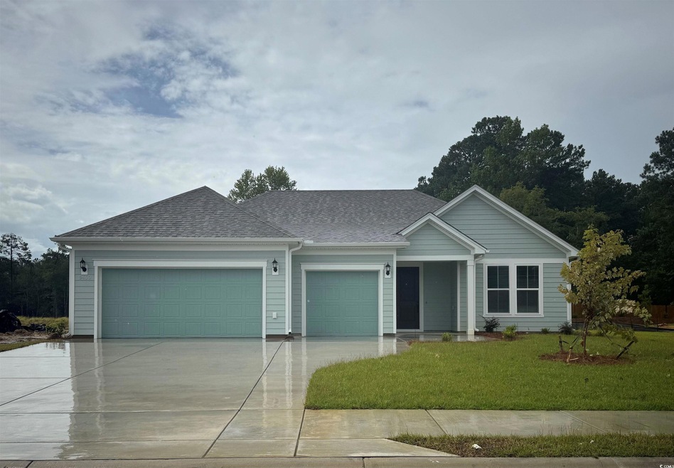 Single story home featuring an attached garage, driveway, a shingled roof, and a front yard