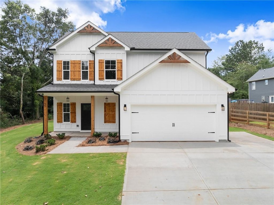 Modern farmhouse with board and batten siding, driveway, covered porch, and a shingled roof