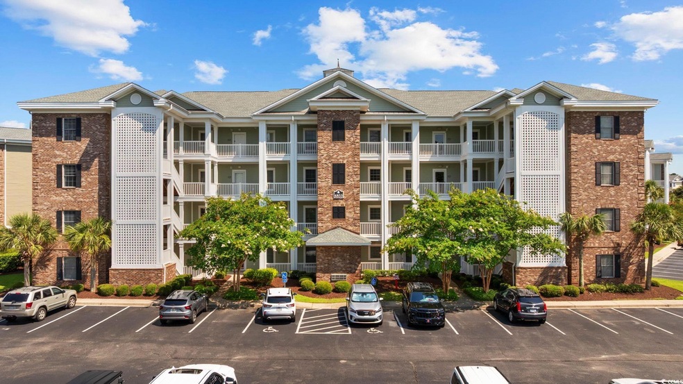 View of building exterior with uncovered parking
