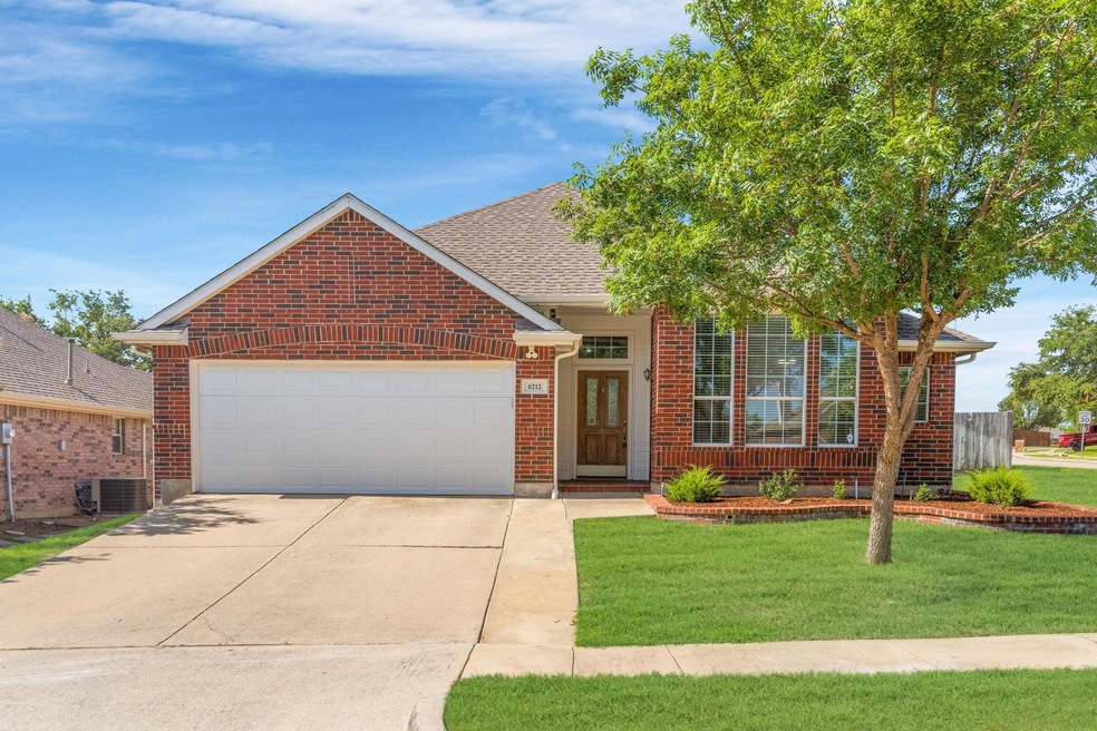 View of front of house with a garage and a front lawn
