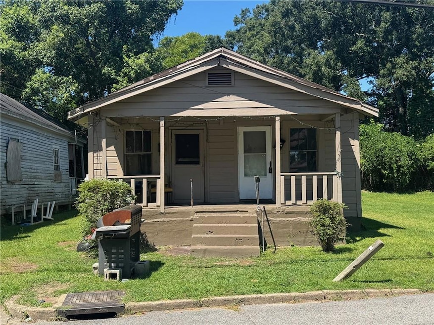 Bungalow-style home featuring a front yard and covered porch