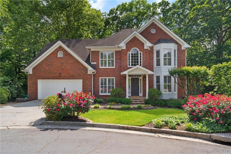 Colonial home with concrete driveway, brick siding