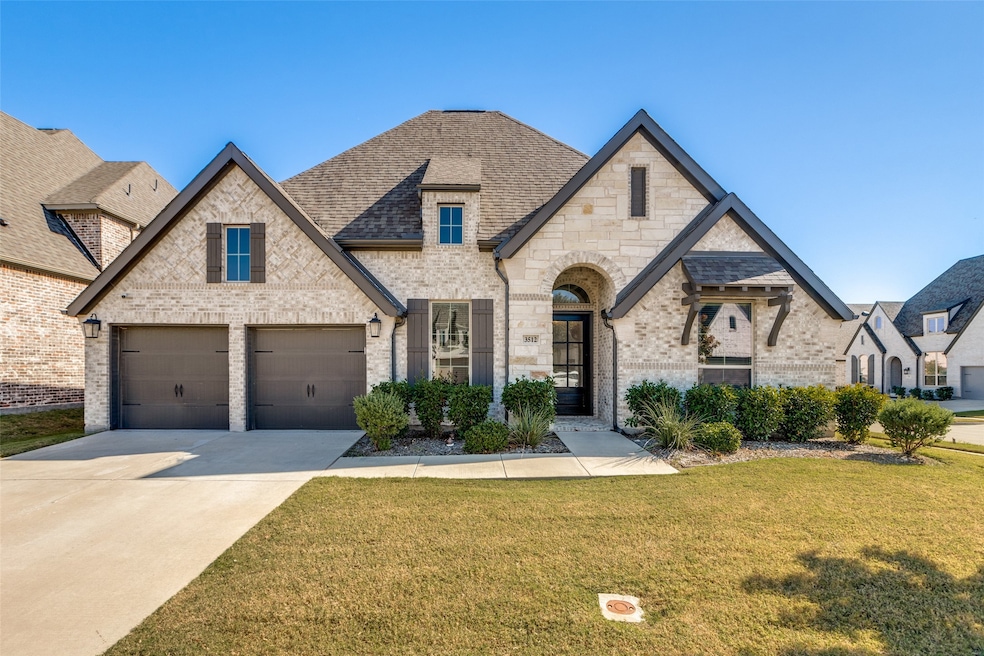 French country inspired facade with a front yard, driveway, brick siding, a garage, and a shingled roof
