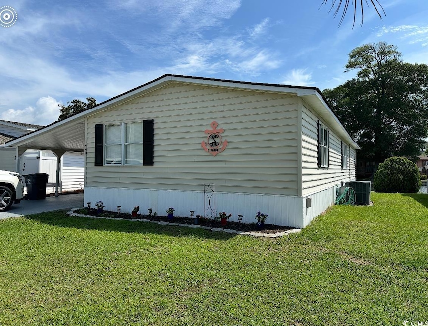 View of home's exterior featuring a lawn and an attached carport
