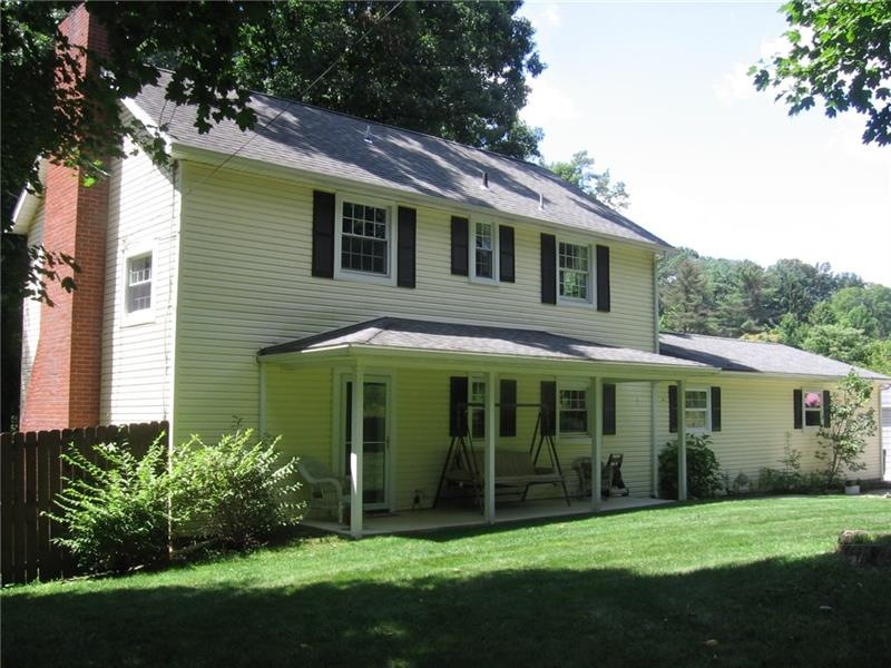 Yellow siding, white trim and black shutters creat