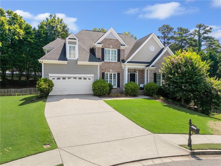 View of front of house with concrete driveway, brick siding, a garage, and a shingled roof
